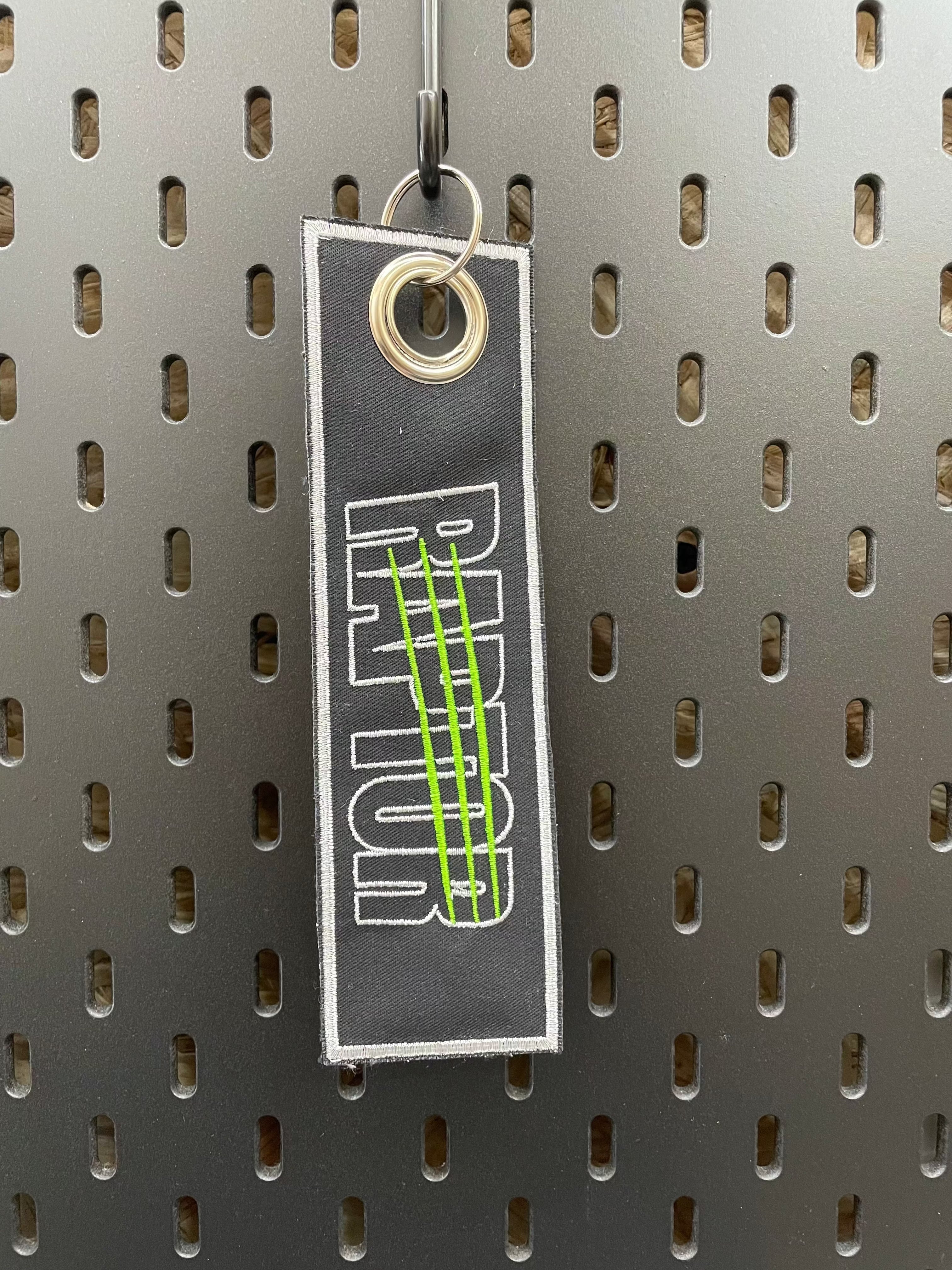 porte-clé brodé Raptor – coloris blanc lettrage phosphorescent