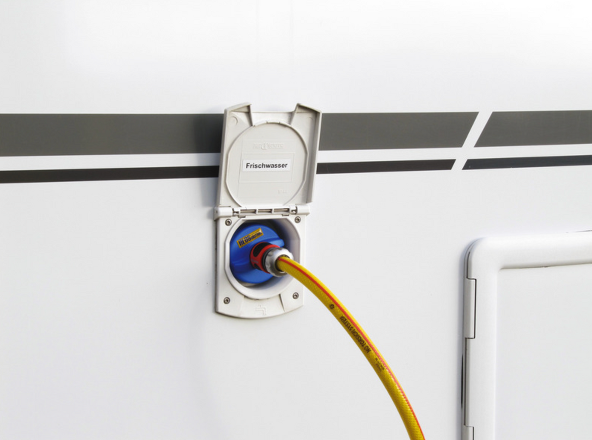 Raccord pour réservoir d’eau HEOSolution installé sur le goulot d’un camping-car avec un tuyau branché