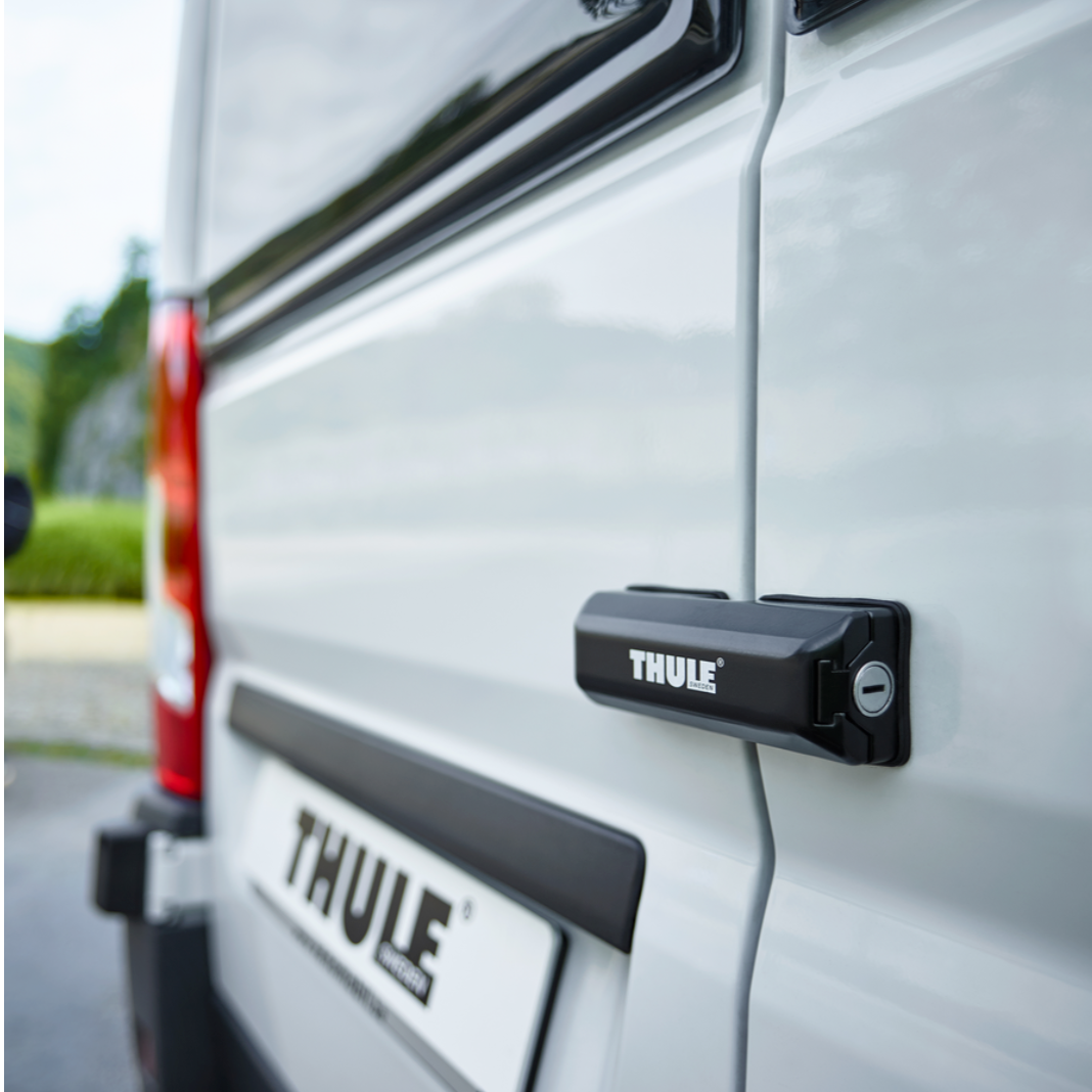 Serrure de sécurité Thule Van Lock noire installée sur la porte arrière d'un van blanc